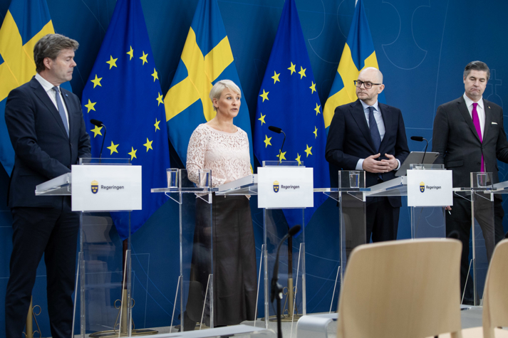 ldre- och socialförsäkringsminister Anna Tenje, arbetsmarknadsminister Johan Britz, Oscar Sjöstedt (SD) och Hans Eklind (KD) bakom varsin talarstol i regeringens pressrum.