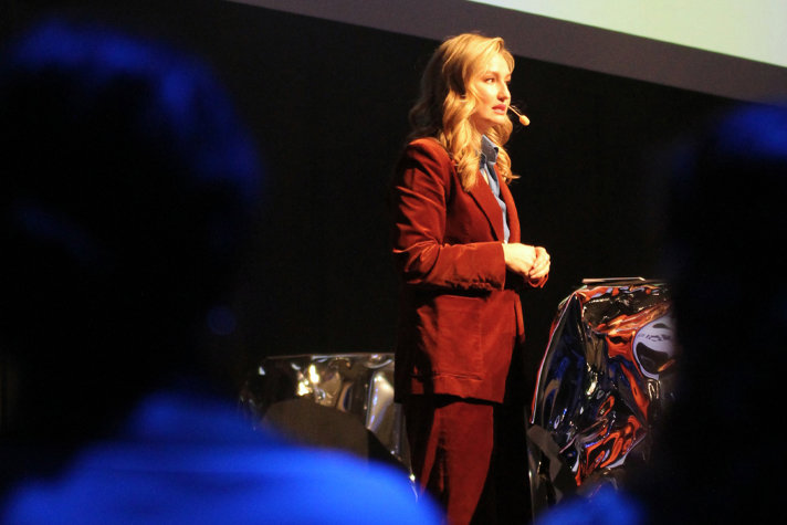 Bilden föreställer Ebba Busch, iförd röd kavaj mot en svart bakgrund.