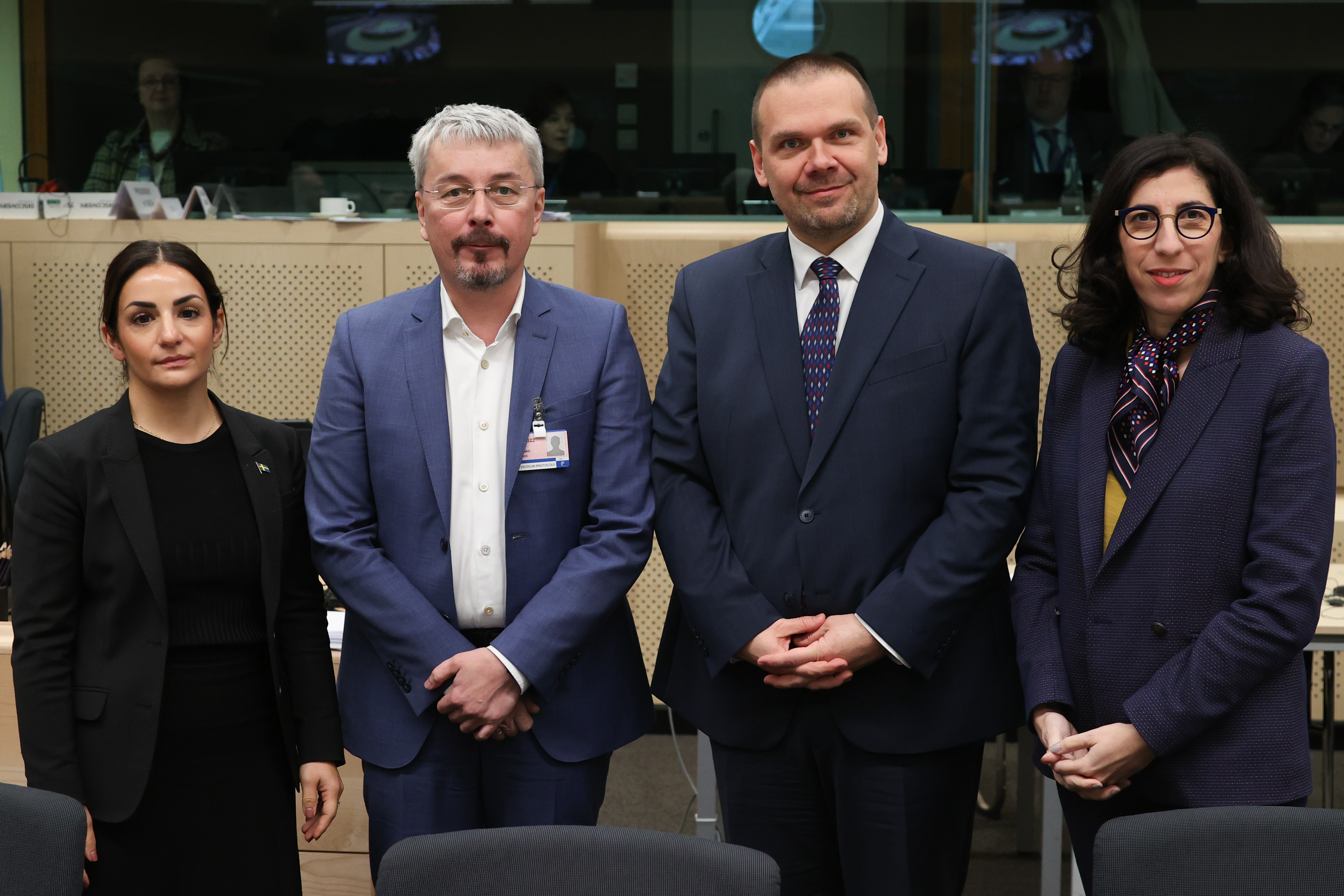 Fyra personer står uppradade bredvid varandra och tittar in i kameran.