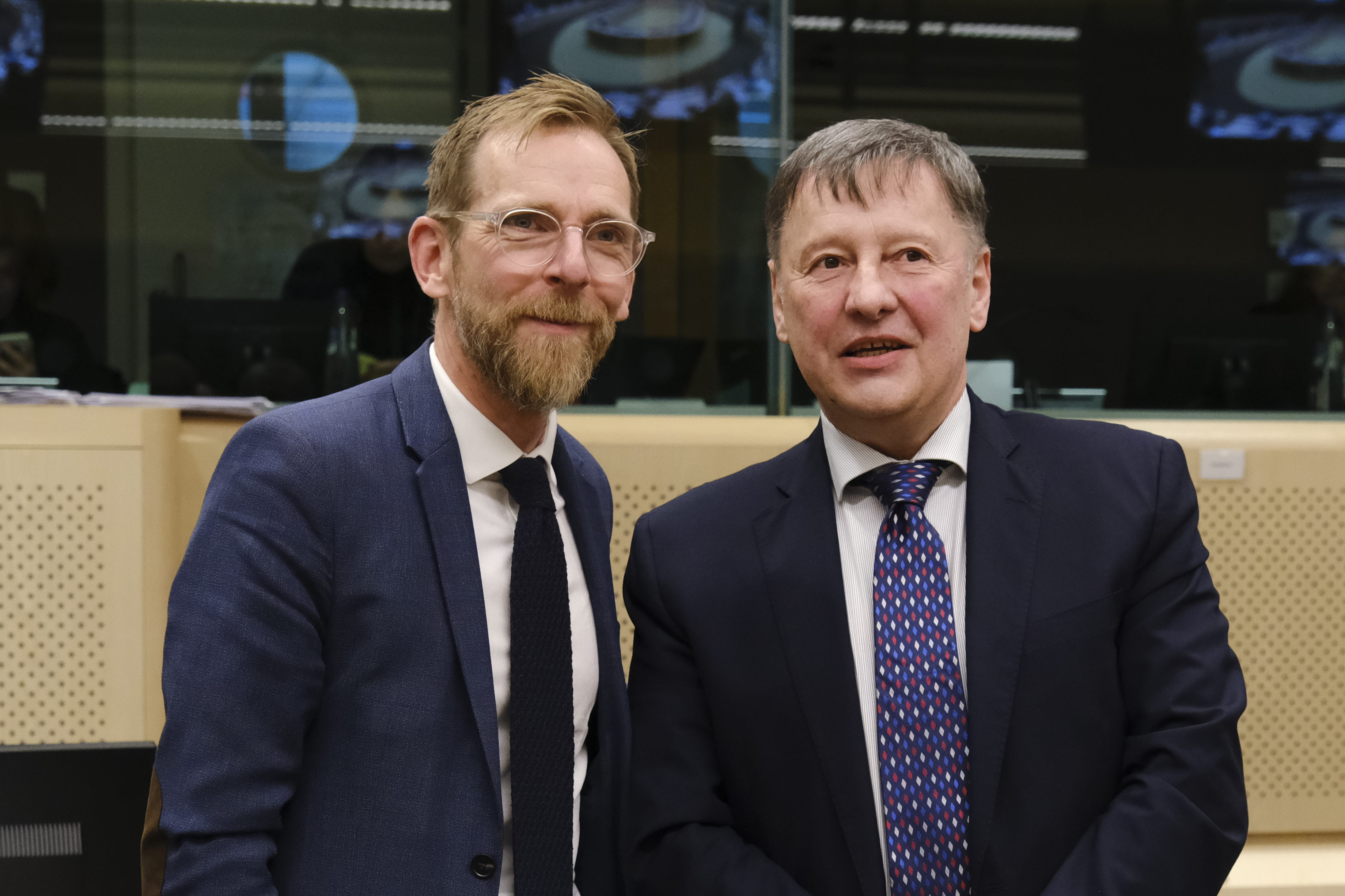 Två personer står bredvid varandra och samtalar medan de tittar mot en kameran.