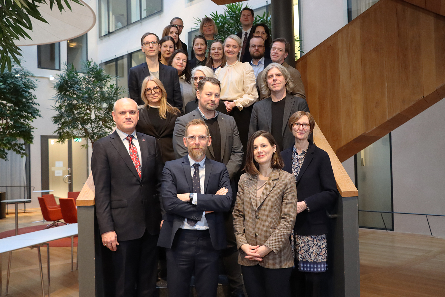 Gruppfoto med ett tjugotal personer. De står i en trappa och tittar mot kameran.