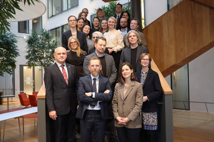 Gruppfoto med ett tjugotal personer. De står i en trappa och tittar mot kameran.
