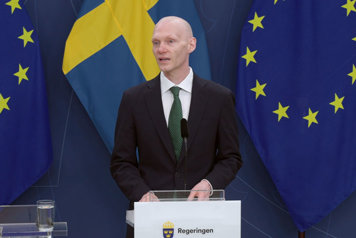 Statsrådet står vid en talarpulpet.