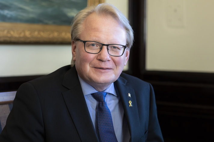Peter Hultqvist i kostym sittande inomhus.