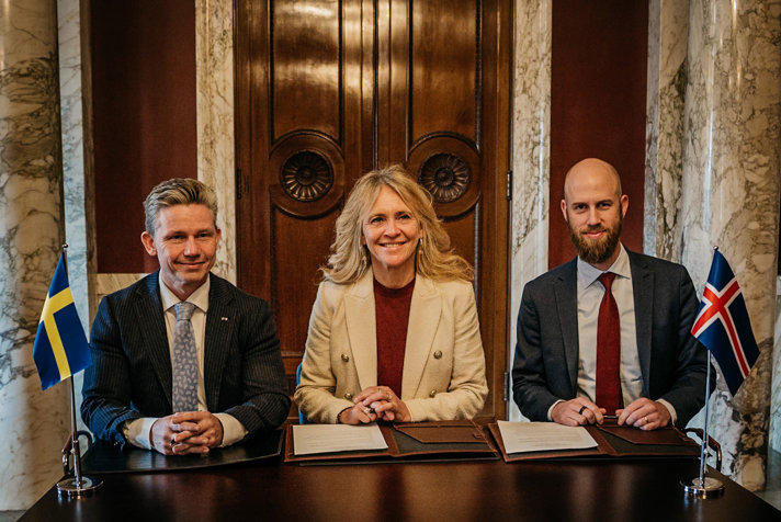 De tre ministrarna sittande bakom ett bord.