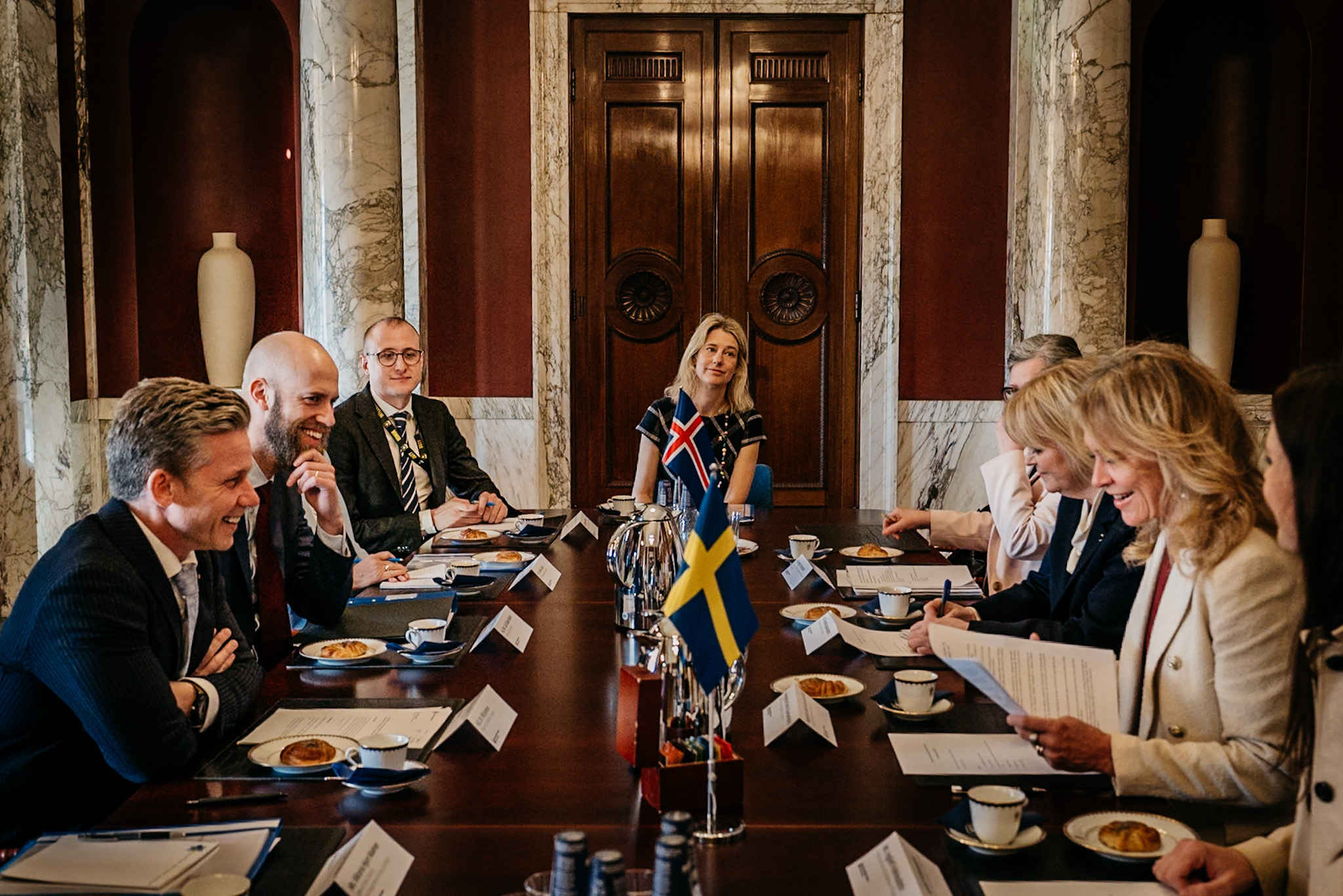 Glada mötesdeltagare runt ett bord.