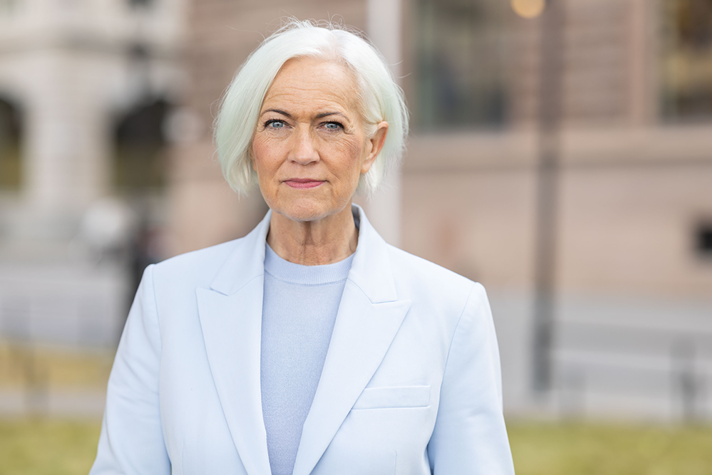 Acko Ankarberg Johansson står utomhus. Hon tittar allvarligt in i kameran.