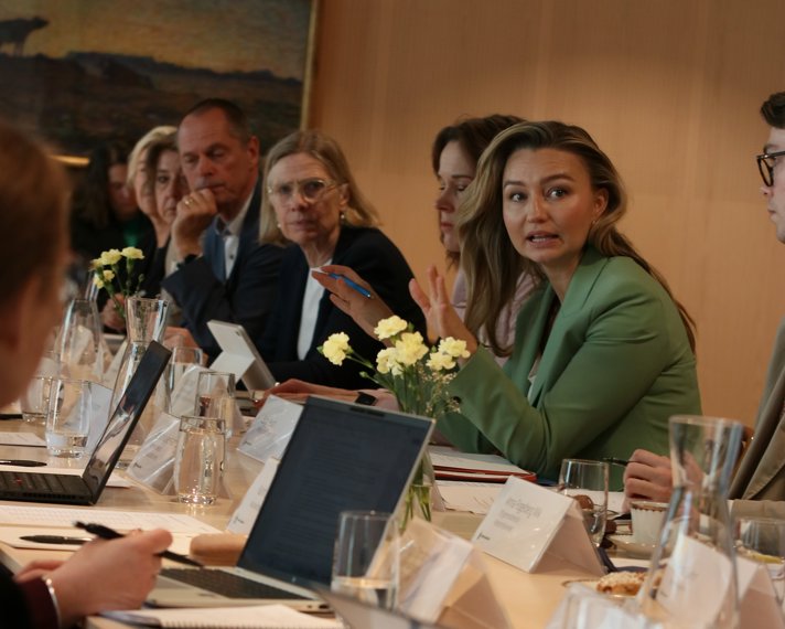 Ebba Busch i diskussion vid ett avlångt bord tillsammans med generaldirektörer och deras medarbetare vid mötet om förenklingsarbetet.