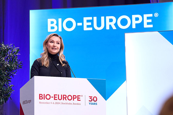 Ebba Busch vid talarstolen på mässan BIO-Europe