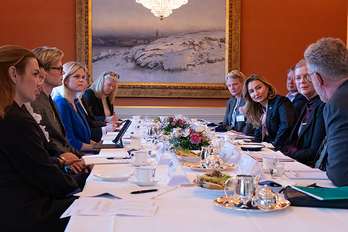 Statsråden och gästerna vi ett dukat bord.