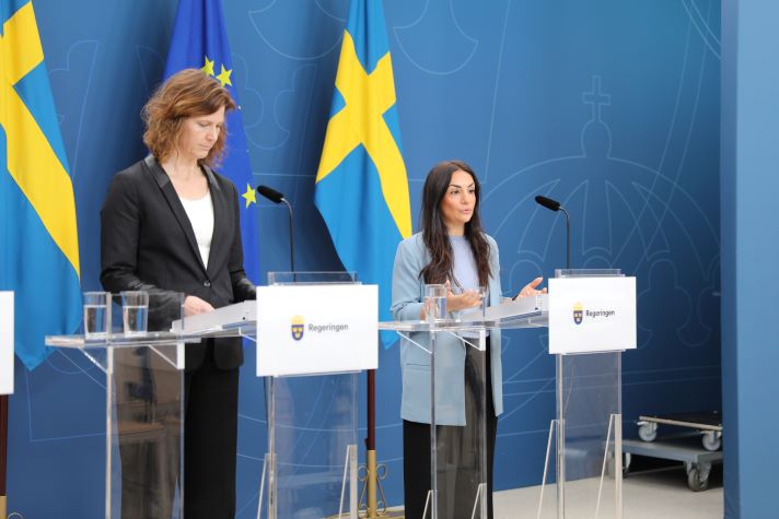 Två statsråd vid varsin talarstol för att presentera den beslutade strategin.