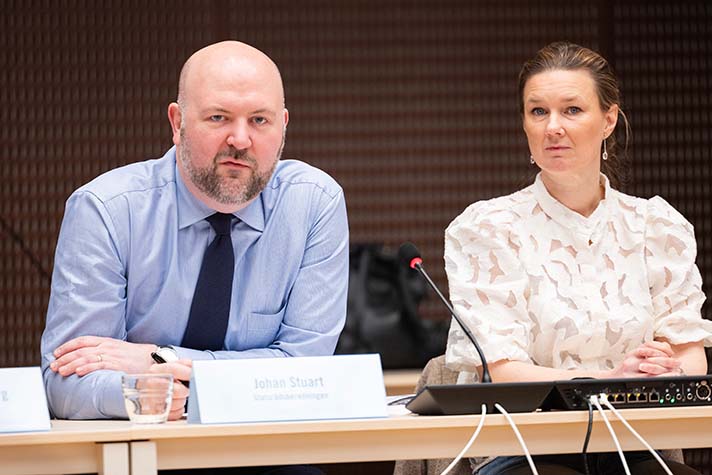 Johan Stuart och Karin Svanborg-Sjövall vid ett mötesbord.