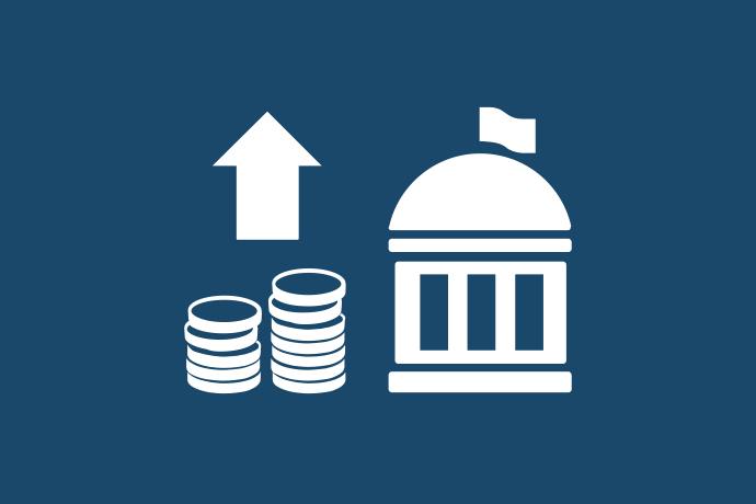 Marinblå bakgrund vita illustrationer, två staplar mynt under en pil som pekar uppåt. Bredvid en byggnad för folkvalda.