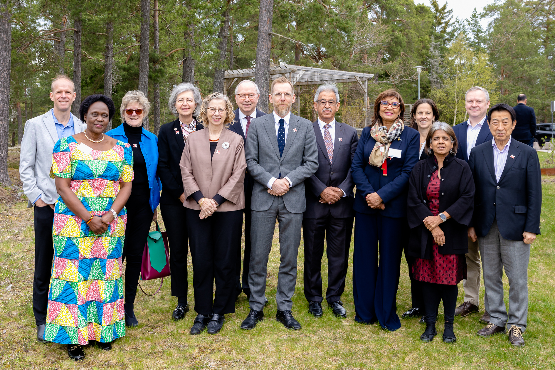 Gruppfoto på medlemmarna i GLG. De står utomhus under några tallar.