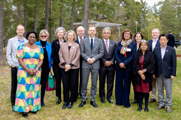 Gruppfoto på medlemmarna i GLG. De står utomhus under några tallar.