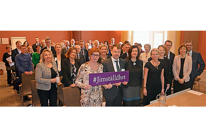 Människor i en undervisningssal. Främsta raden håller upp en skylt: #Jimställdhet Människor i en undervisningssal. Främsta raden håller upp en skylt: #Jimställdhet