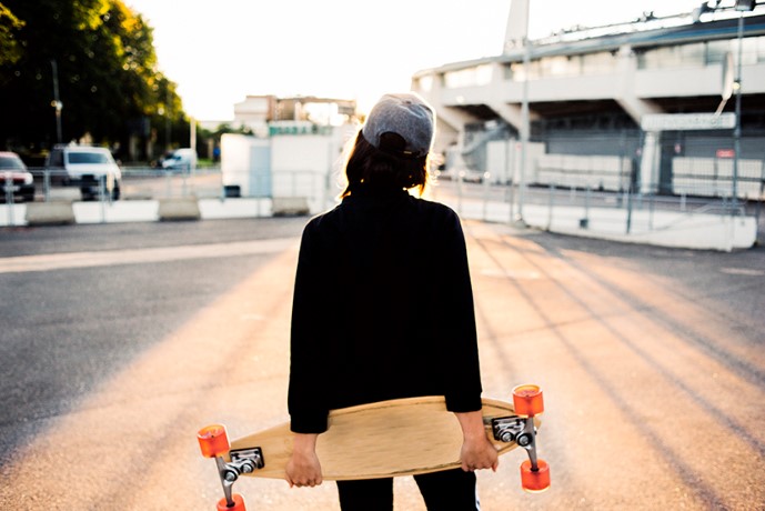 Ung kvinna med keps och skateboard Ung kvinna med keps och skateboard