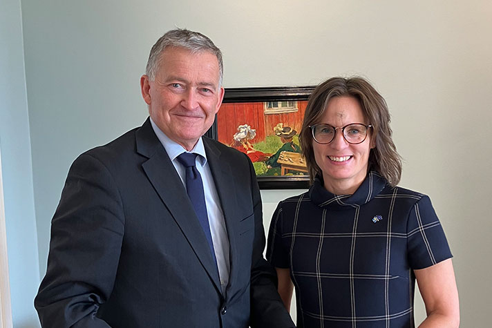 Anders Ahnlid och Jessika Roswall står inomhus bredvid varandra och tittar in i kameran. I bakgrunden syns en vägg med en tavla.