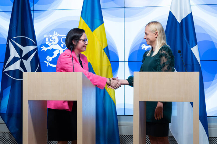 Malmer Steneregard och Valtonen skakar hand under en pressträff.