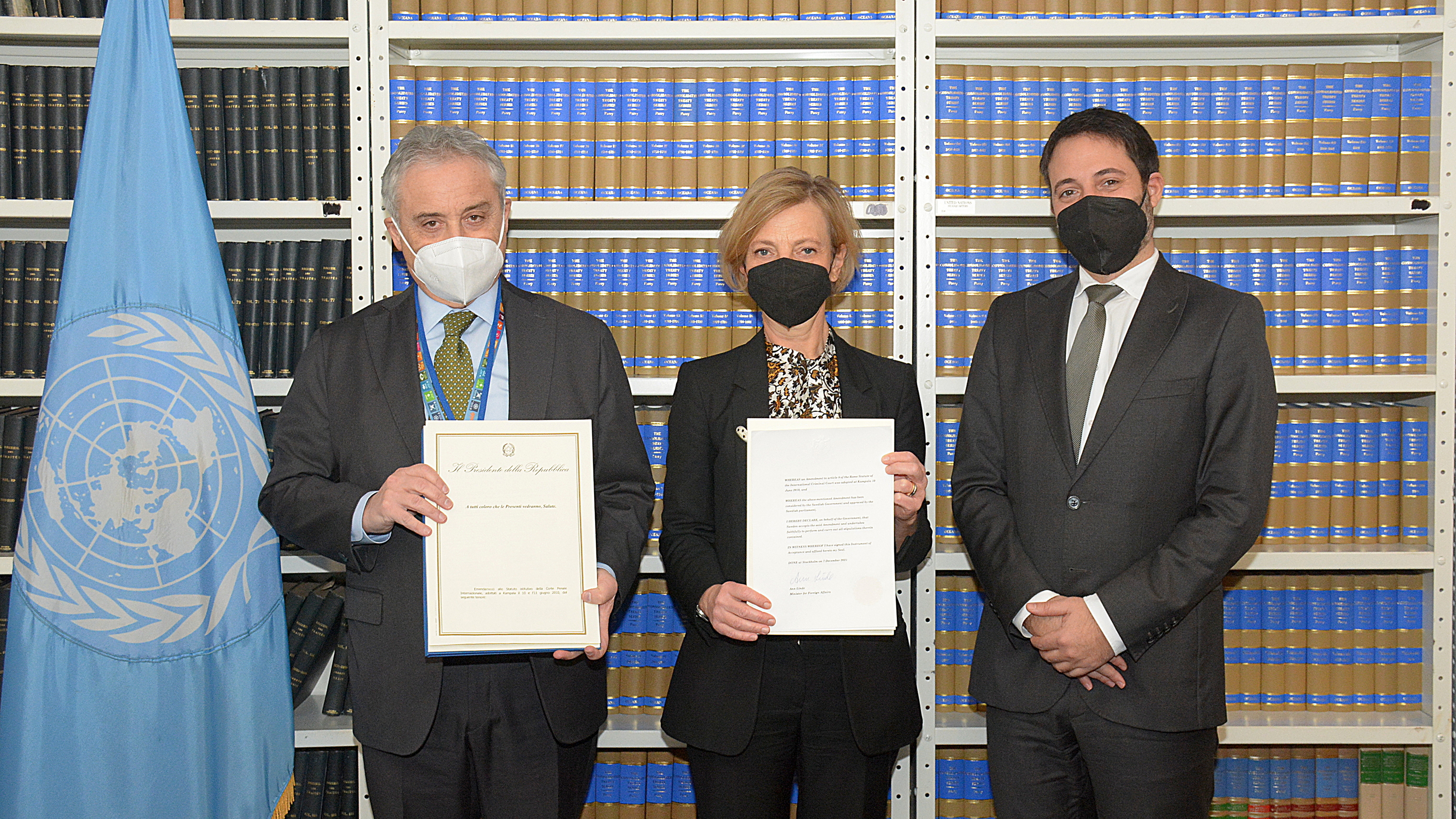 Gruppbild på Maurizio Massari, Anna-Karin Eneström och David K. Nanopoulos som håller upp dokument