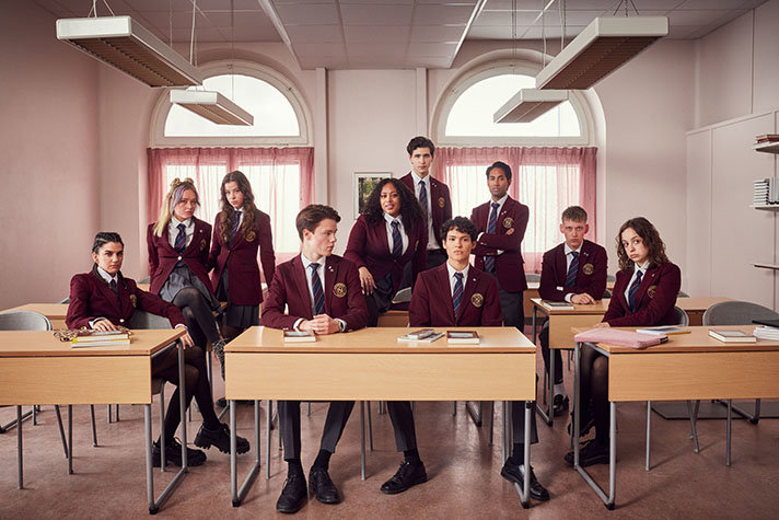 Ungdomar med skoluniform i ett klassrum. Från tv-serien Young Royals