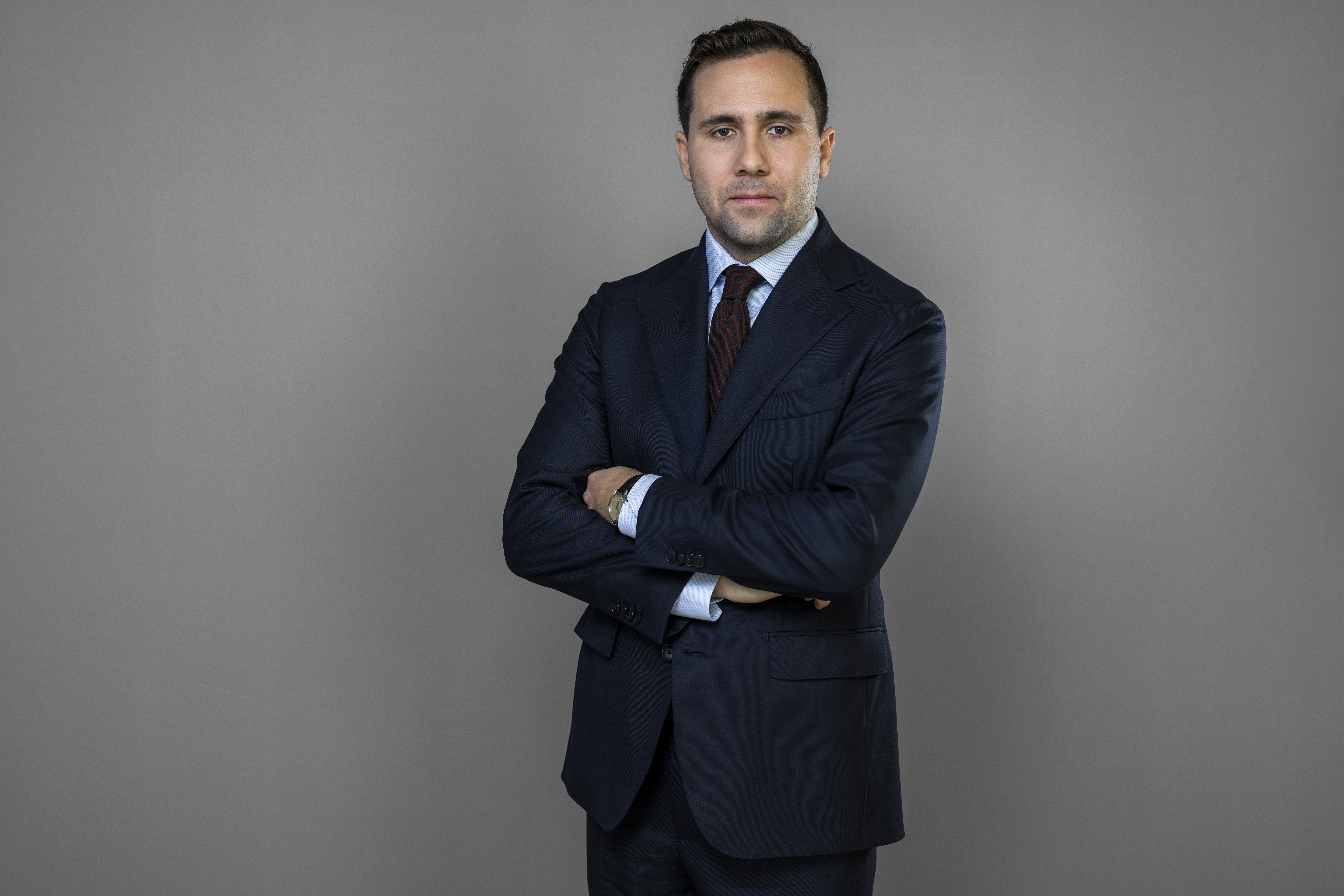 Bistånds- och utrikeshandelsminister Benjamin Dousa framför grå vägg.