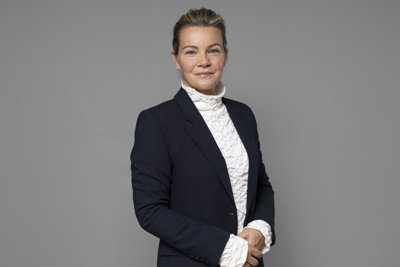 Karin Juhlin framför grå bakgrund.