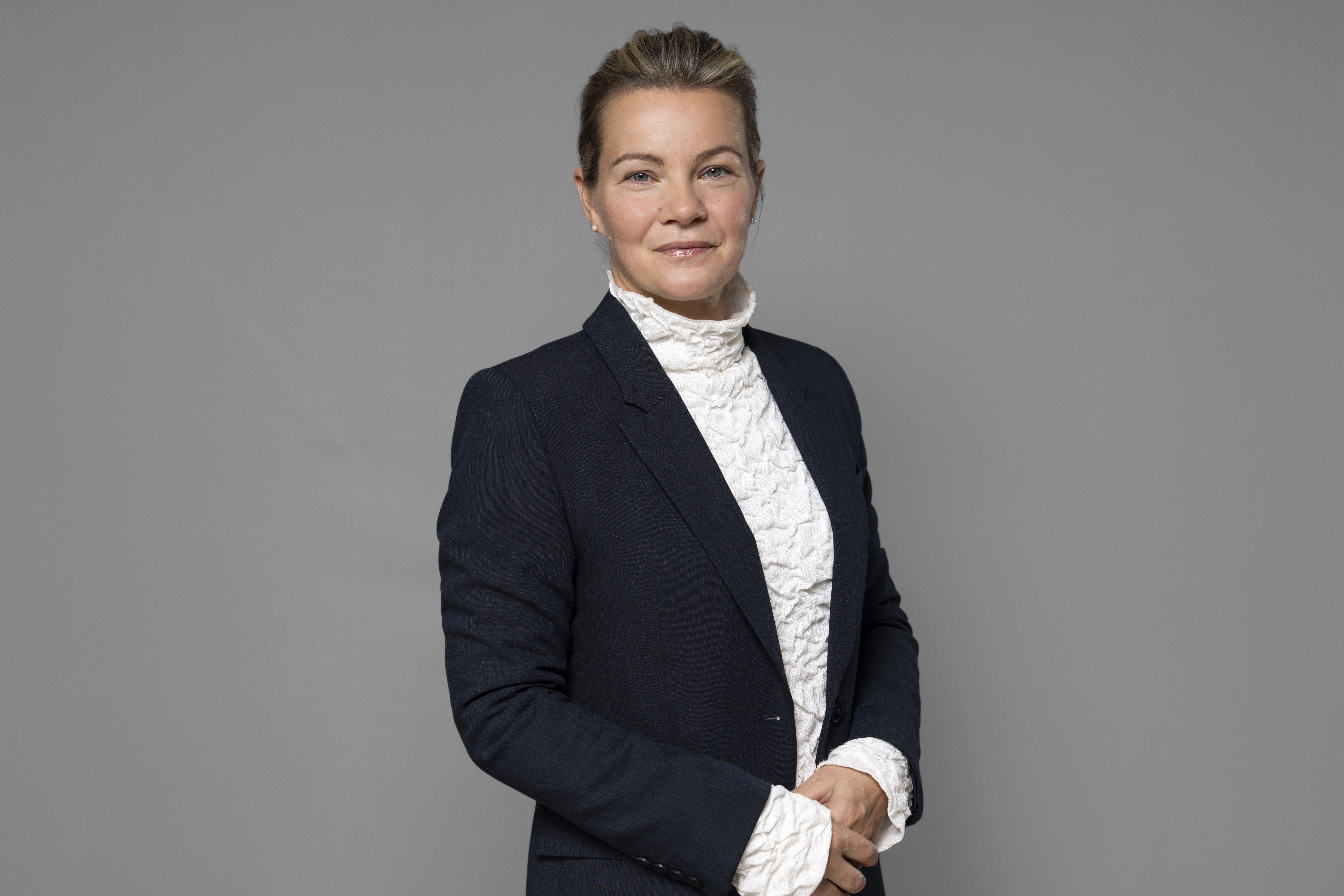 Karin Juhlin mot grå bakgrund. 