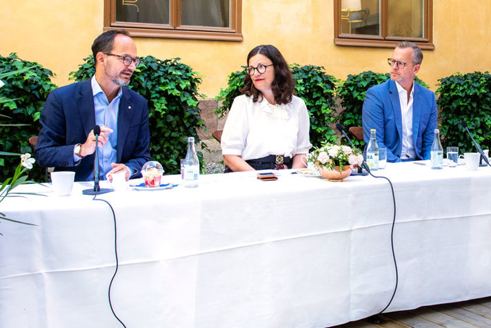 Tomas Eneroth, Anna Ekström och Mikael Damberg sitter vid ett bord och samtalar.